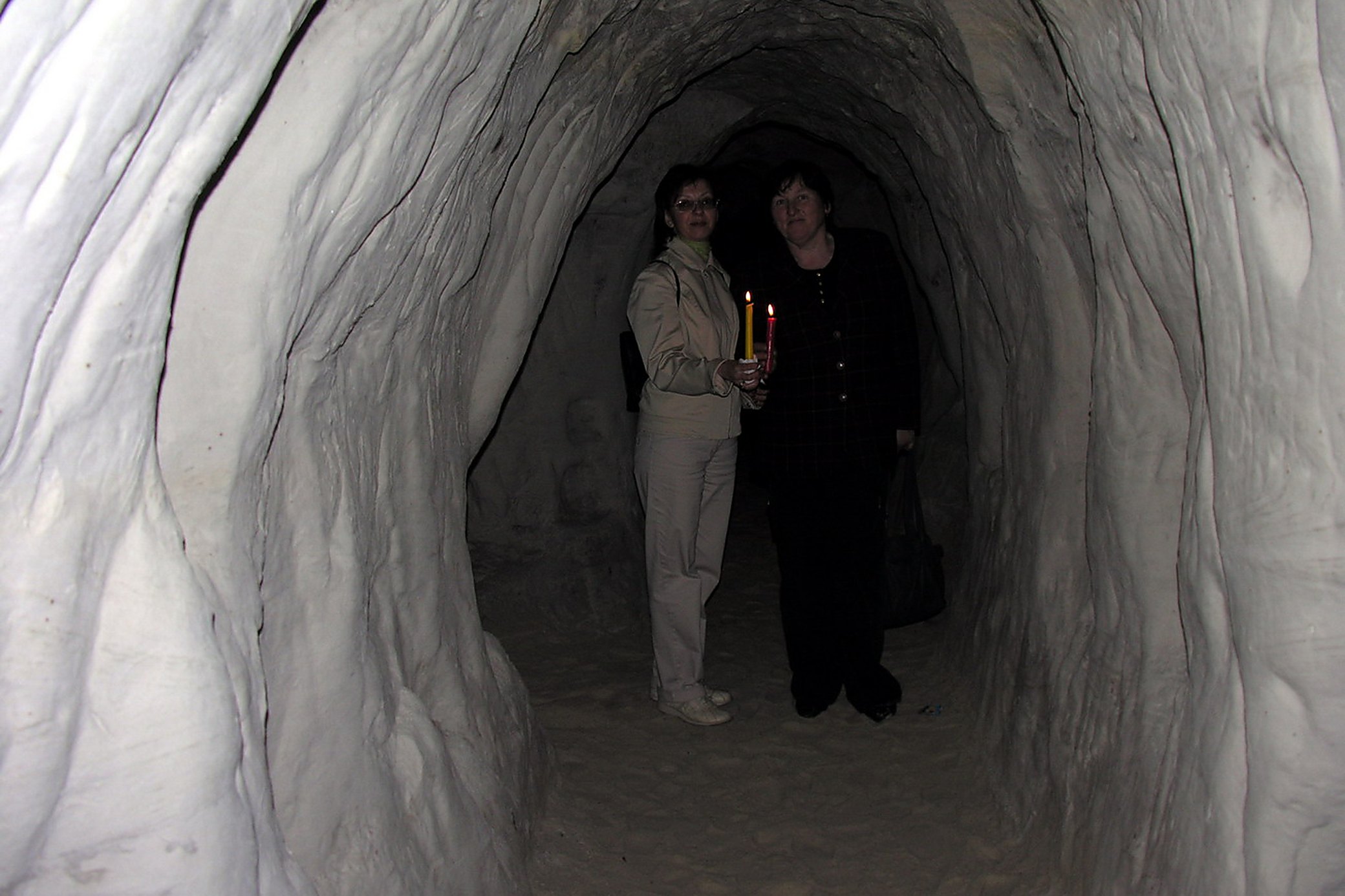 Two visitors and one candle, which is about as much light as you get down there.