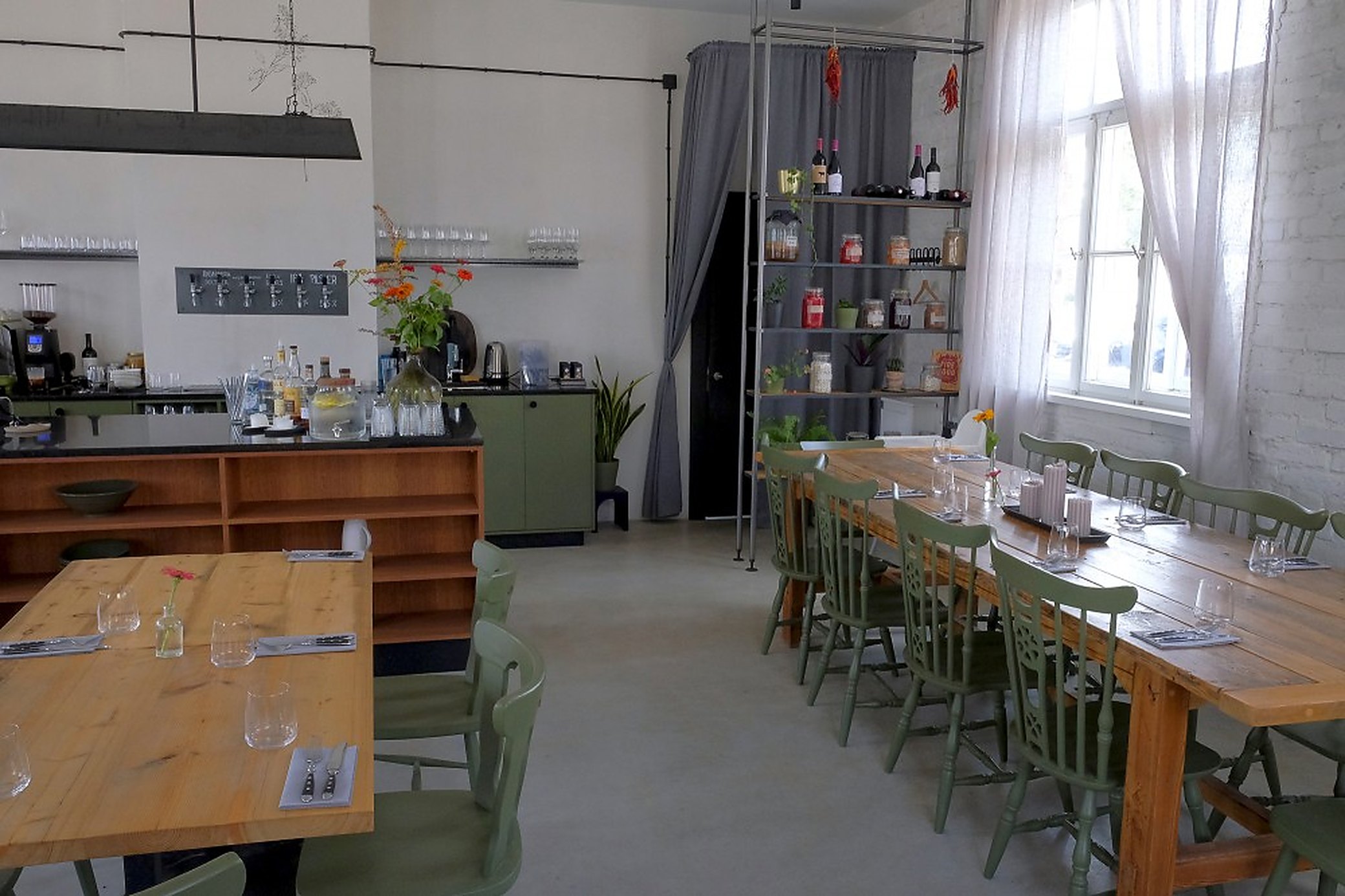 Inside KOPA. One long table down the middle, and the kitchen open at the end of it.