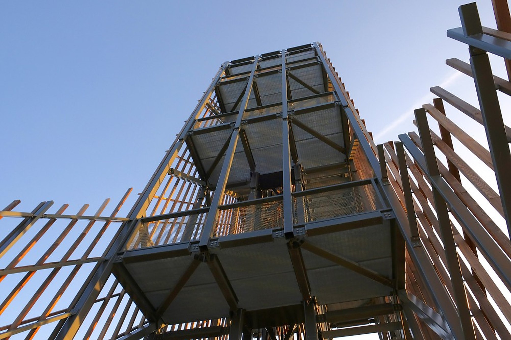 Looking up the frame from the base. The platforms step up the inside, so the view builds as you climb.