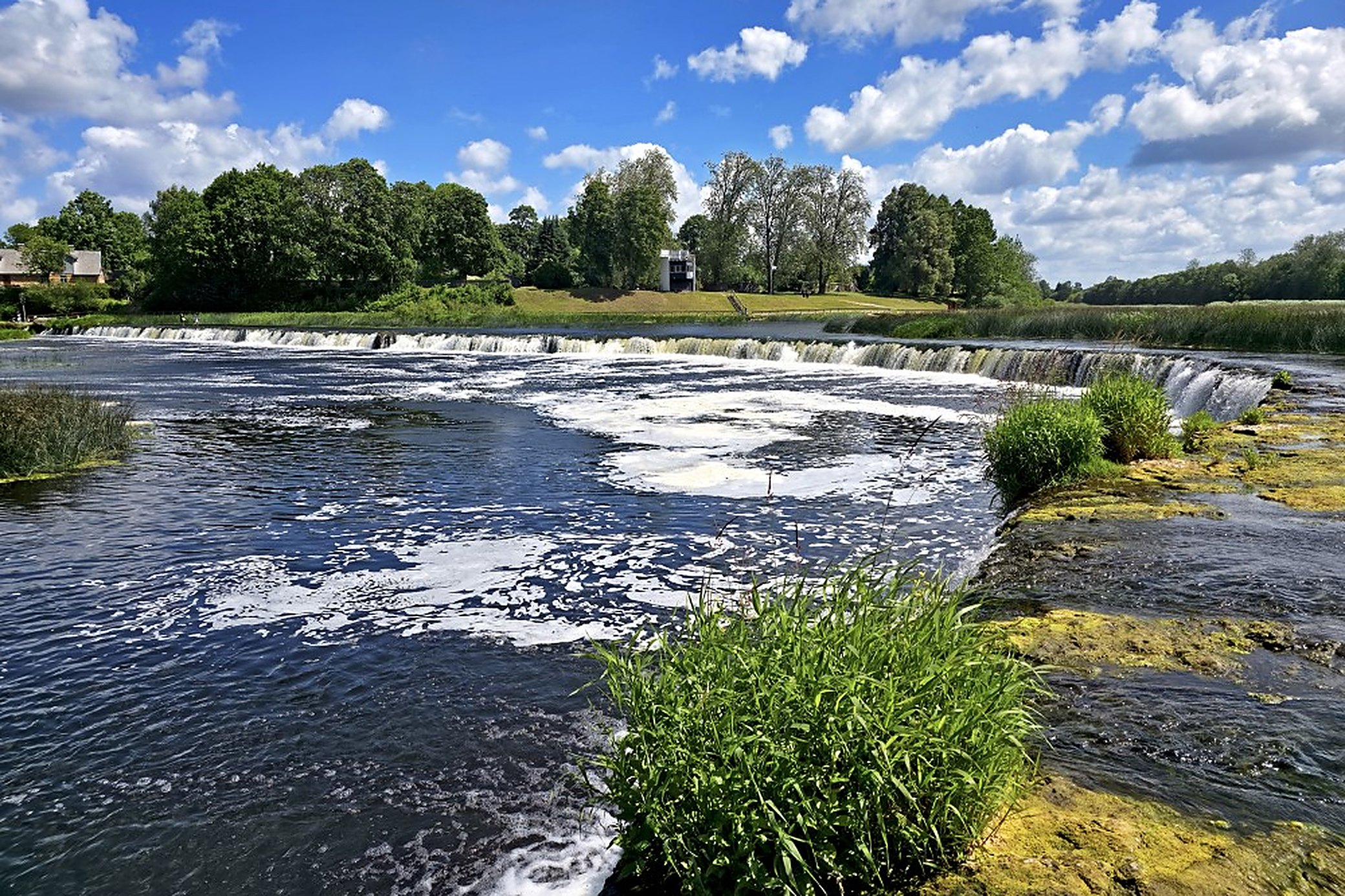 Low summer water, with the whole ledge showing at once. In the spring melt it vanishes under one unbroken sheet.