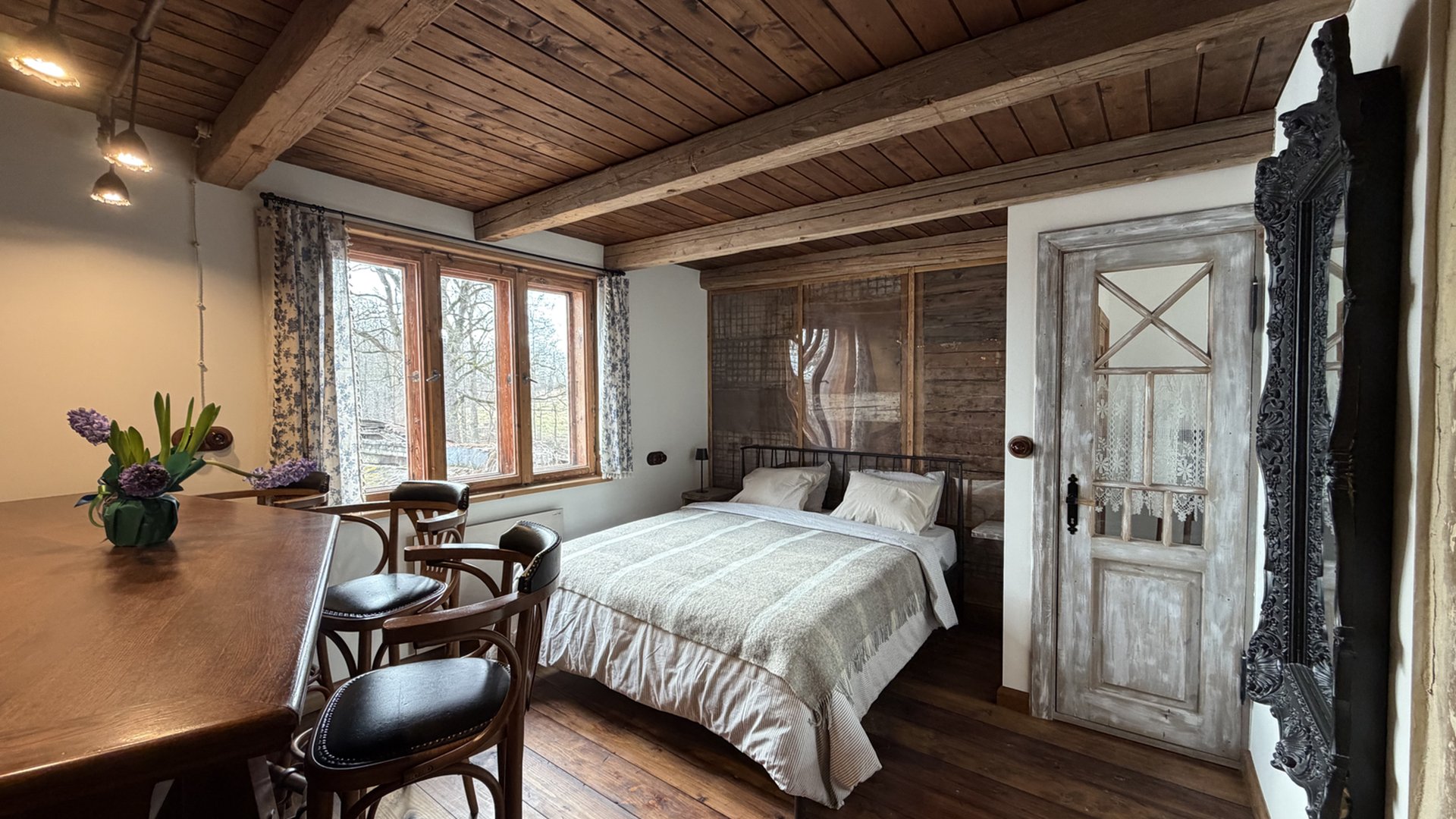 Attic apartment with exposed timber ceiling, queen bed and a long dining table