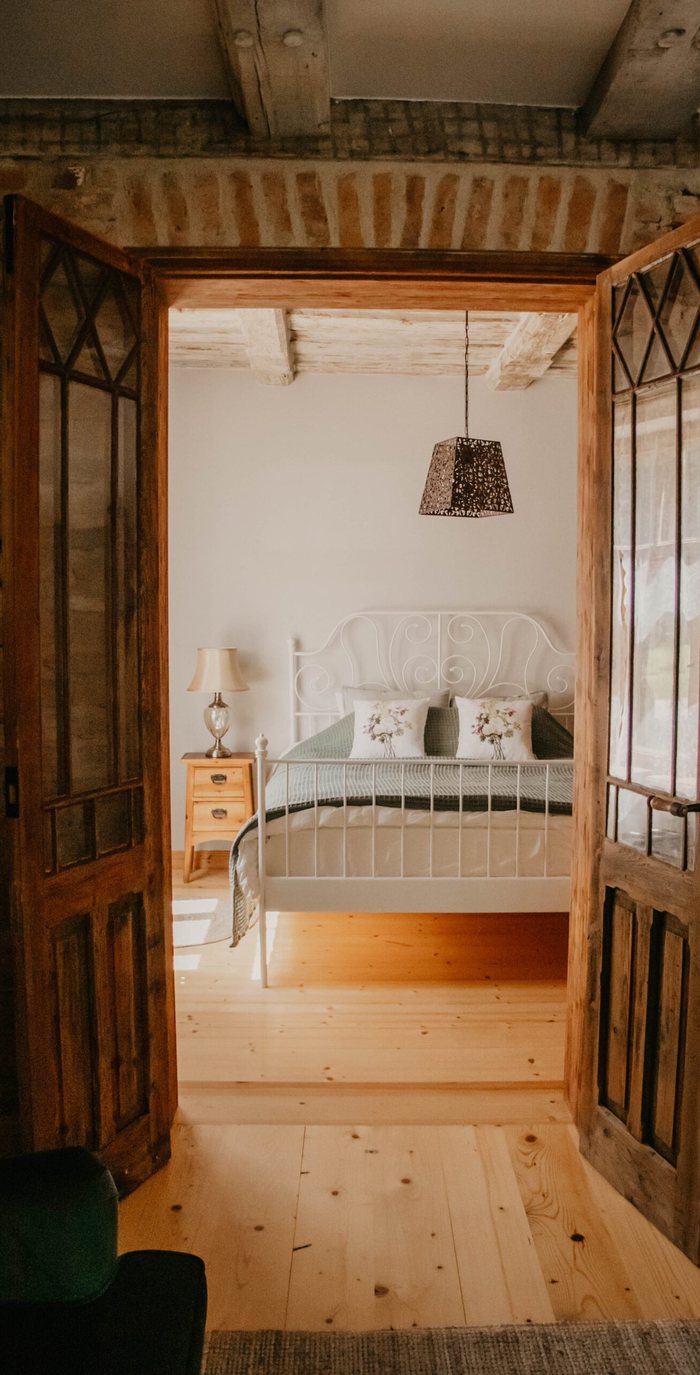 Queen bed seen through original glazed double doors in the Rumba apartment